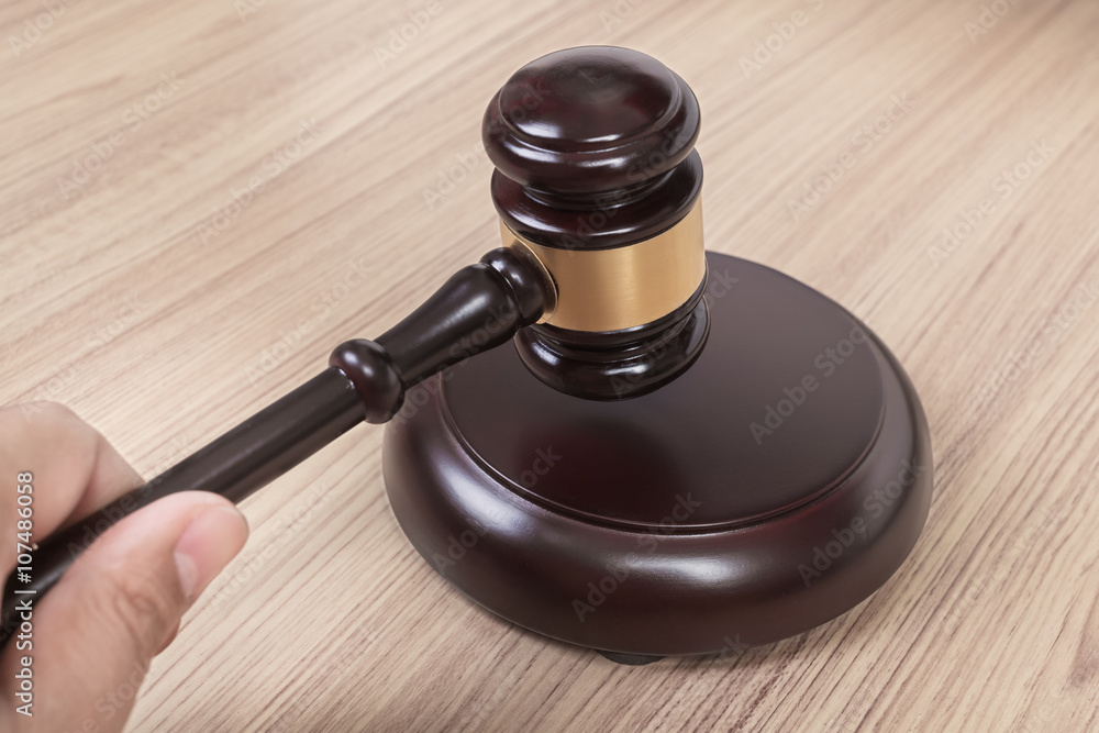 Hand and Justice hammer or judge gavel made from wooden isolated on white background Hand and Justice hammer or judge gavel made from wooden isolated on white background