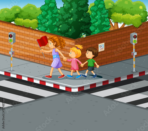 Woman helping kids crossing the street