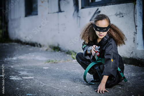 Mixed race girl in martial arts uniform and mask