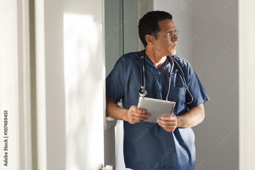Hispanic doctor using digital tablet in hallway Hispanic doctor using digital tablet in hallway