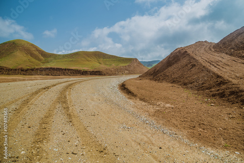 Unpaved curiving road in Iraqi desert after rain