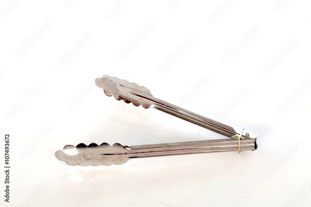 Serving kitchen tongs on white background, selective focus