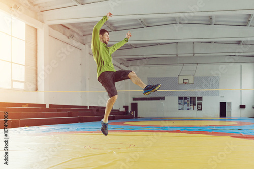Man slacklining walking and balancing on a rope, slackline in a sports hall