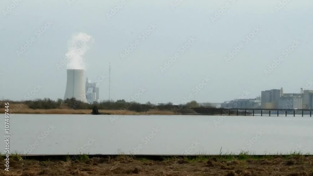 Industrial landscape pan shot on dock in harbor. View to warehouses panning to view to power plant with smoking chimney. Industrial landscape pan shot on dock in harbor. View to warehouses panning to view to power plant with smoking chimney.