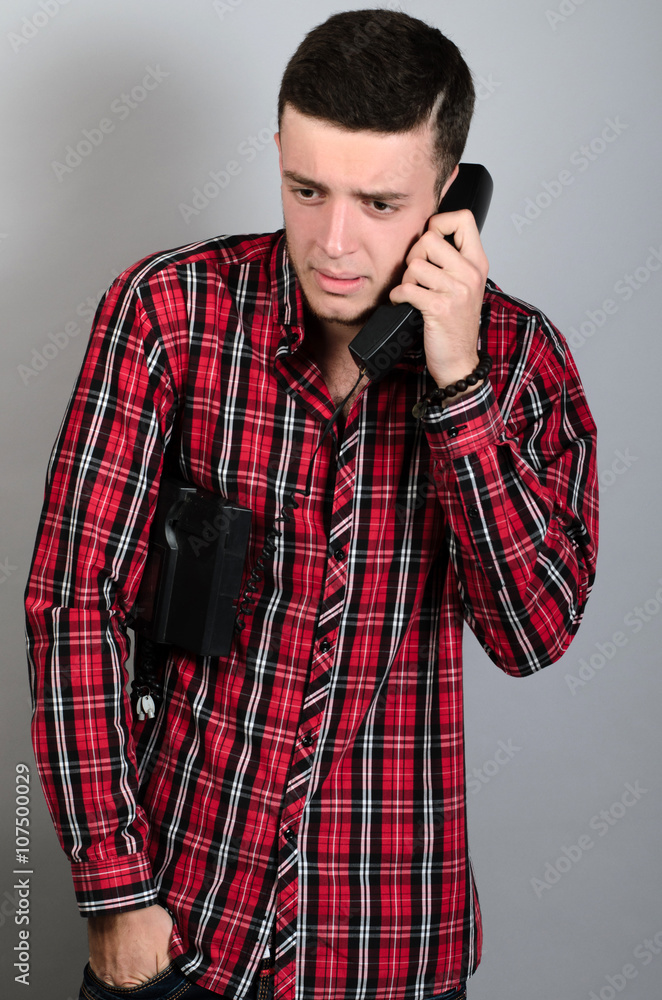 Guy using telephone over grey Guy using telephone over grey