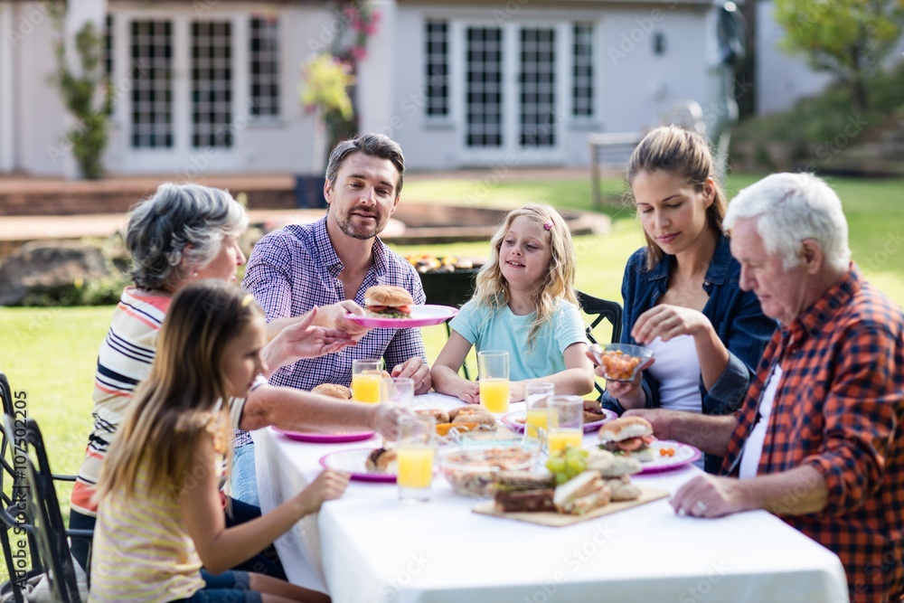 Obraz premium Happy family having lunch in the garden