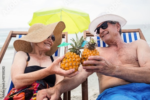 Obraz na plátně Happy senior couple relaxing on deckchairs