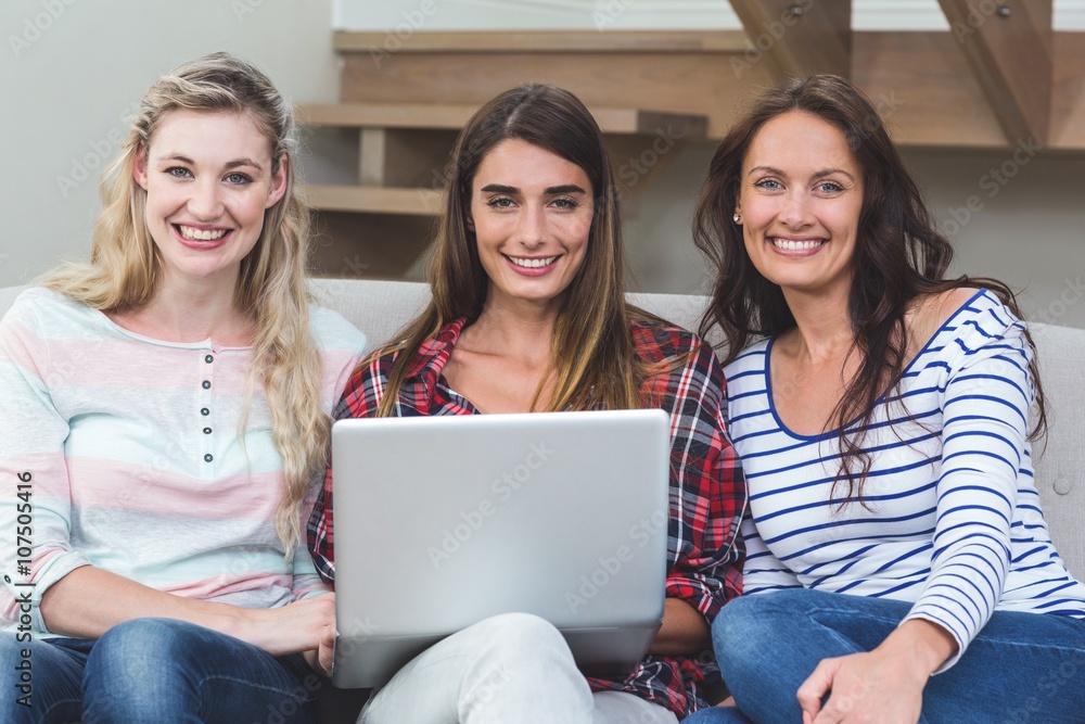 Friends sitting on sofa and using laptop Friends sitting on sofa and using laptop
