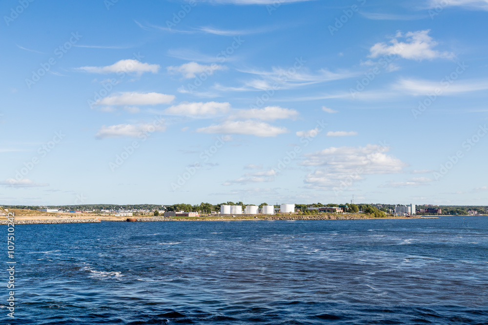 White Oil Tanks Between Blue Sky and Sea