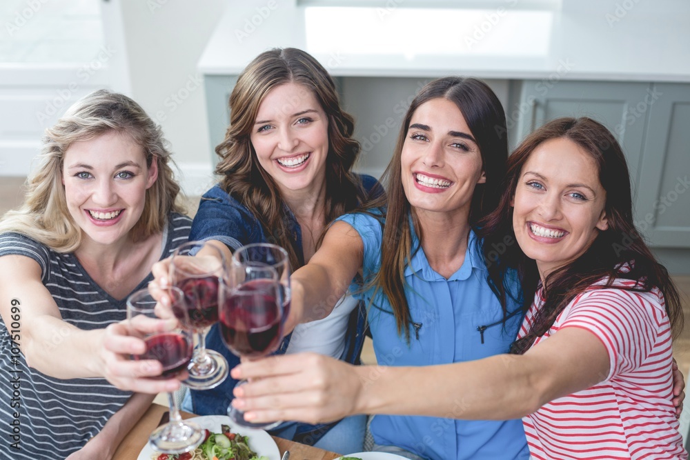 Friends toasting glass of wine while having meal Friends toasting glass of wine while having meal