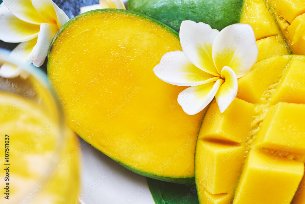Fresh mango on a wooden tabel with tropical background. Soft focus.