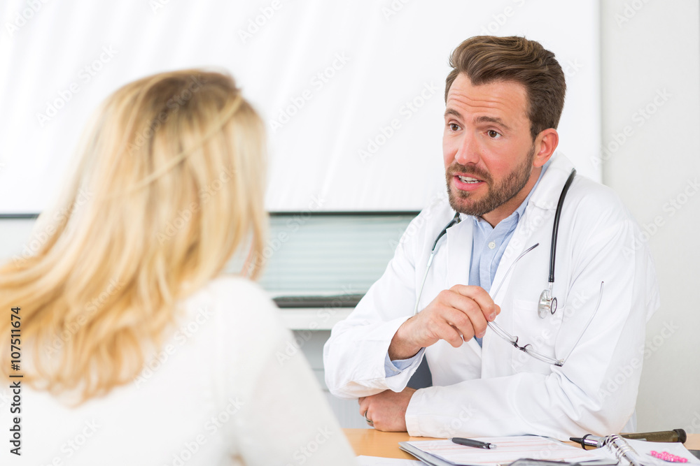 Fototapeta premium Young attractive doctor listening his patient
