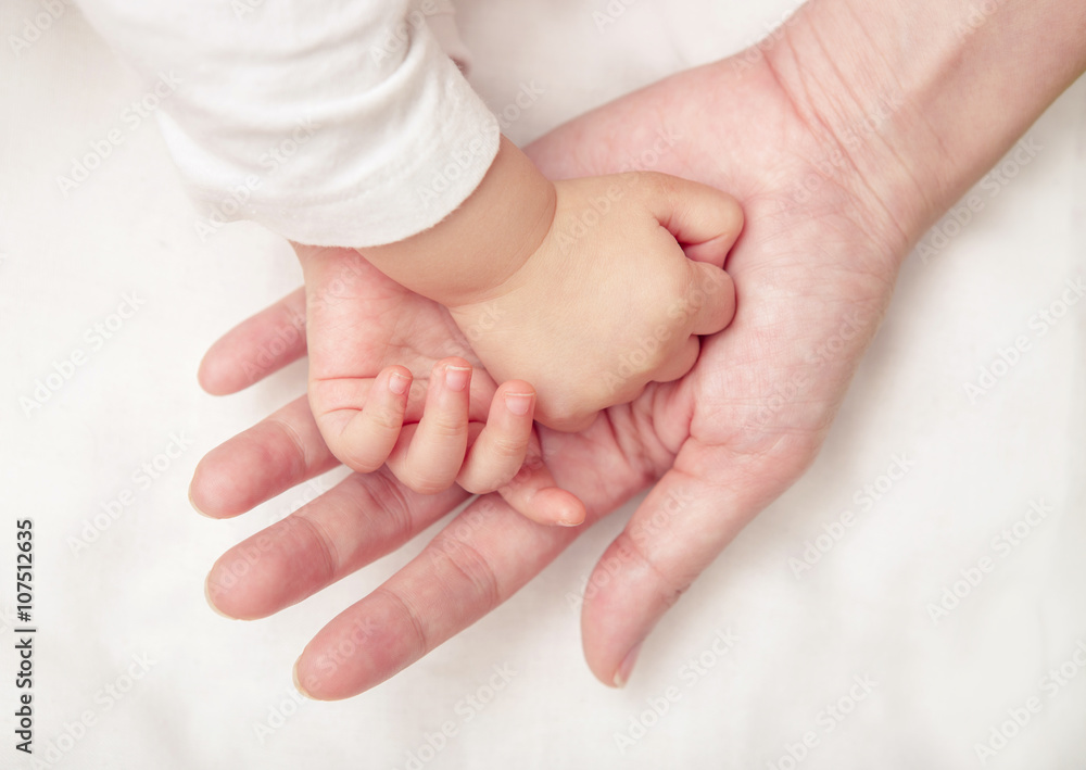 Baby hand gently holding adult's finger (Soft focus and blurry) Baby hand gently holding adult's finger (Soft focus and blurry)