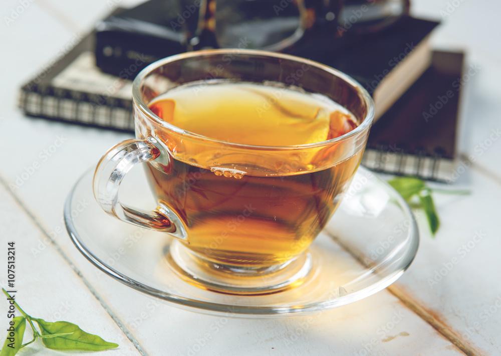 Cup of tea and book on white wooden table