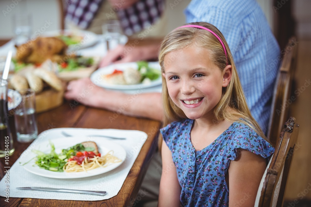 Smiling girl sitting at dining table Smiling girl sitting at dining table