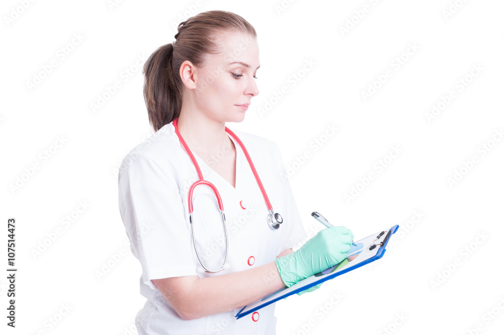 Serious and confident woman doctor writing something on cardboar Serious and confident woman doctor writing something on cardboar
