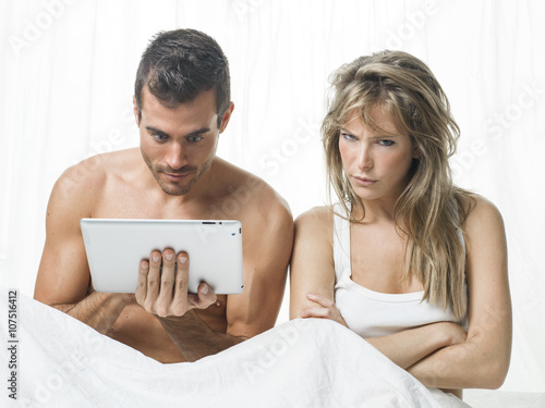 uncommunicative couple on bed in white  photo