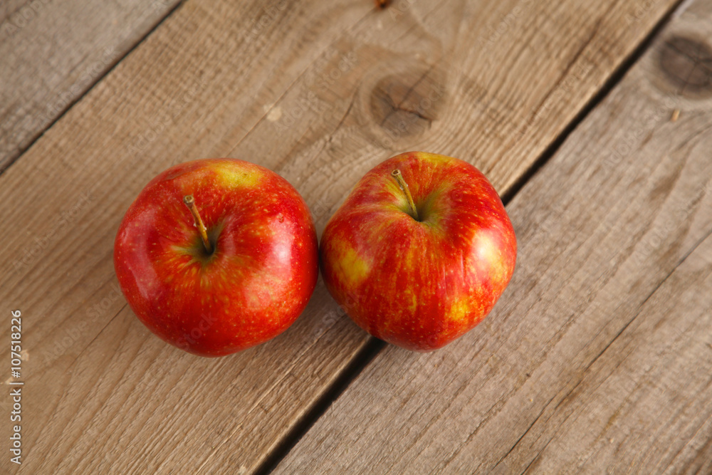 Red apples on a wooden plate on the table Red apples on a wooden plate on the table