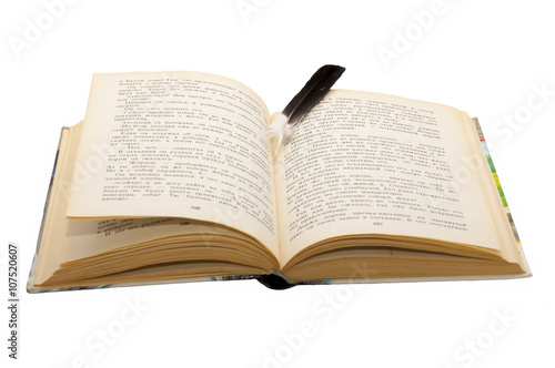Open book/Open book with a large black bird's feather as a bookmark between the pages , on a white background