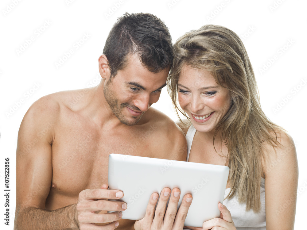 attractive couple watching things in a tablet attractive couple watching things in a tablet