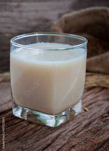 Soy milk in white glass on wooden background