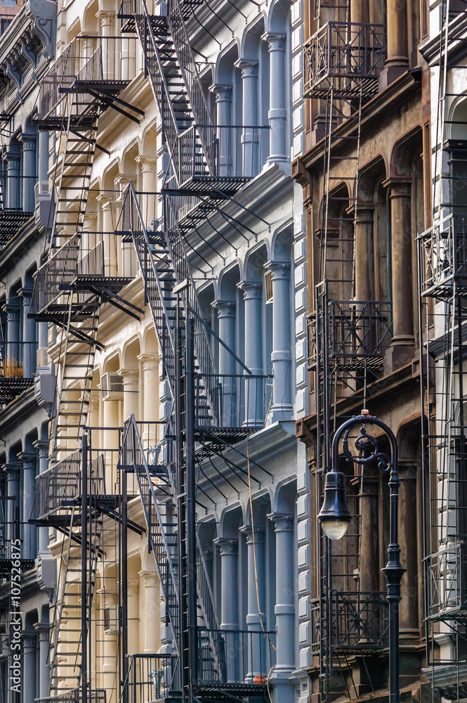 Obraz premium Painted cast iron facades in Manhattan's Soho neighbourhood with columns and fire escapes, New York City