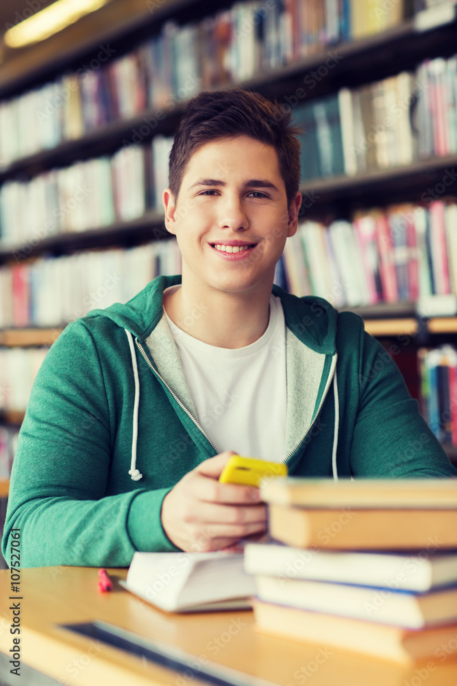 male student with smartphone and books in library male student with smartphone and books in library
