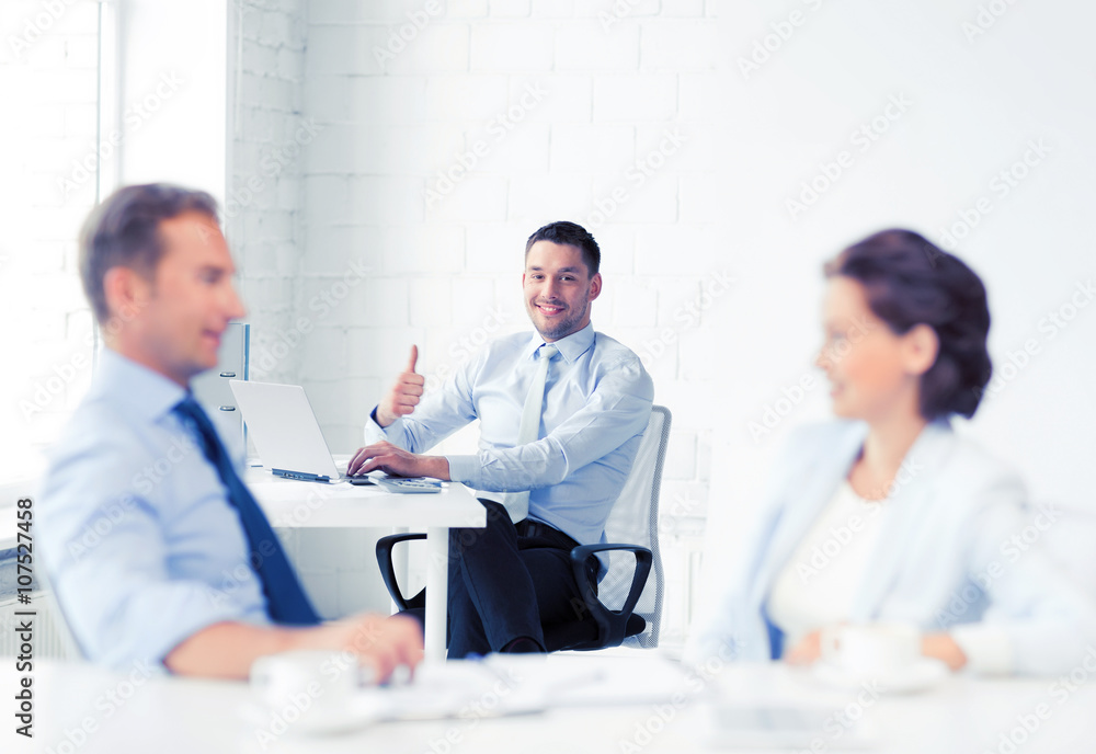 Obraz premium happy businessman showing thumbs up in office