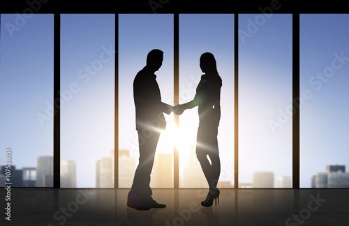 business partners silhouettes shaking hands