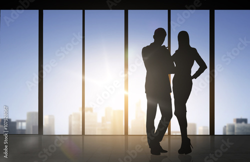 silhouettes of business partners over office
