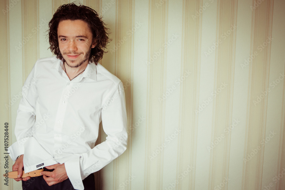 Handsome bearded brunette groom getting ready for wedding, putti