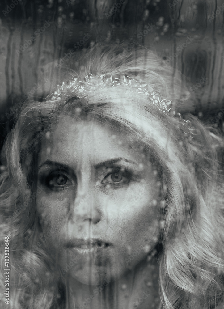 Beautiful romantic blonde bride posing near rainy window face cl Beautiful romantic blonde bride posing near rainy window face cl
