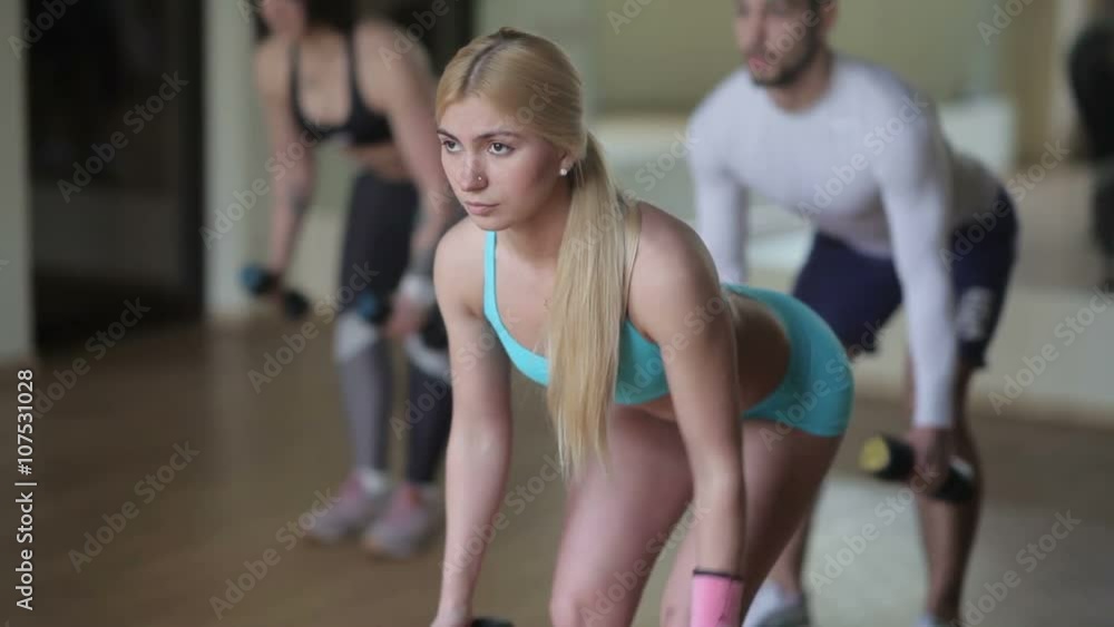 Beautiful girl doing exercises with dumbbells Beautiful girl doing exercises with dumbbells