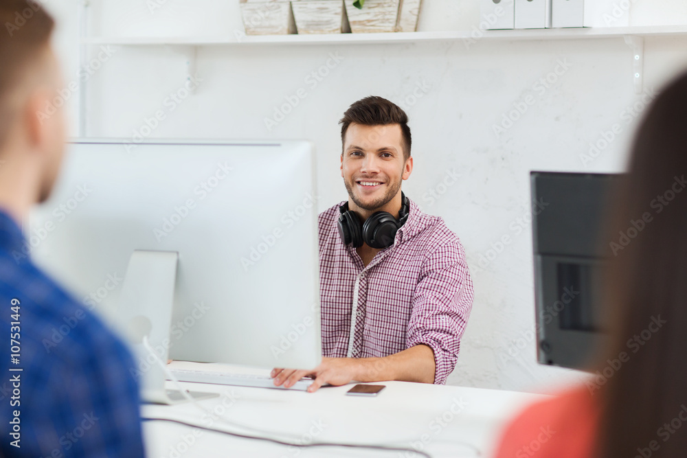 happy young man or student with computer at office happy young man or student with computer at office