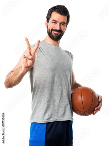 Man playing basketball doing victory gesture © luismolinero
