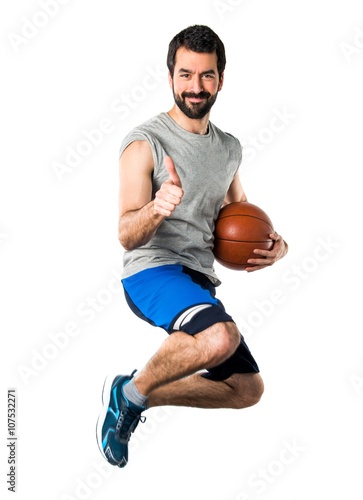 Man playing basketball with thumb up