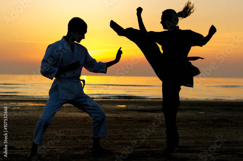 Artial marts fight between master and his pupil at the beach during the sunrise