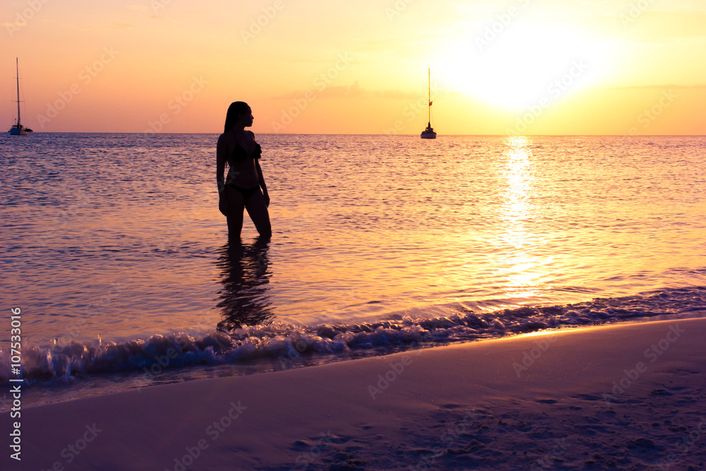 woman enjoying the sunset on the beach woman enjoying the sunset on the beach