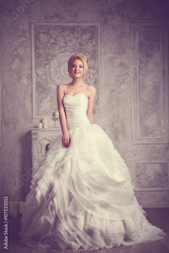 Studio portrait of beautiful young bride in white dress