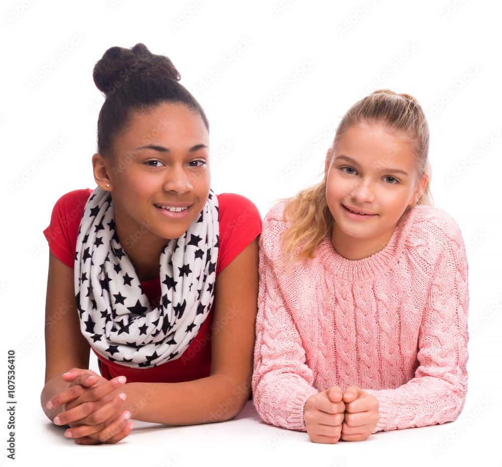 two smiling teenage girls lying on the floor two smiling teenage girls lying on the floor