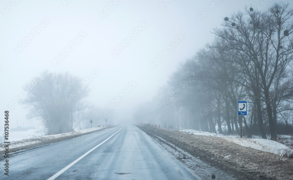 foggy road with dirty snow on sides foggy road with dirty snow on sides