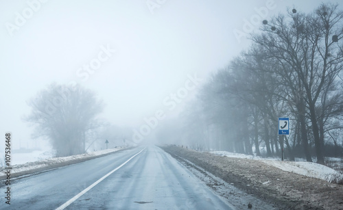 foggy road with dirty snow on sides