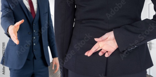 Composite image of businesswoman with fingers crossed