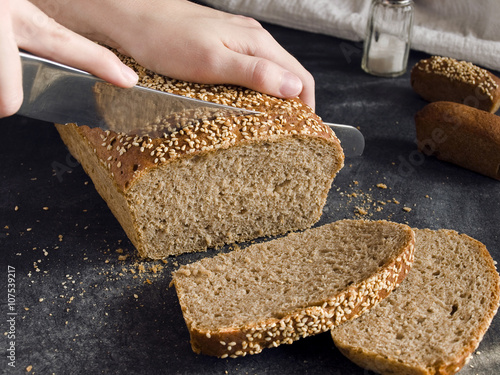 Cutting rye-wheat bread with a knife 