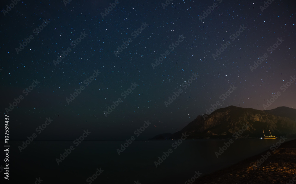 Fototapeta premium Night starry sky at the sea coast in Cirali, Turkey - landscape exterior.