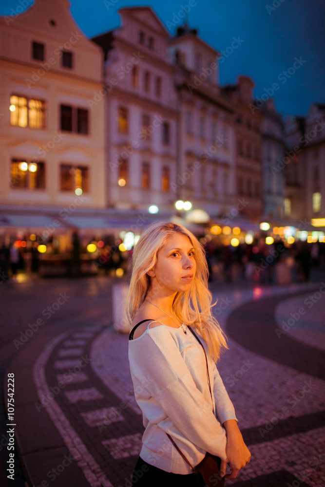 Beautful happy tourist blonde woman posing in evening Prague str