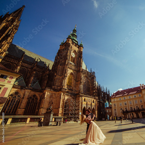 Newlywed couple dancing & hugging near baroque christian cathedr photo