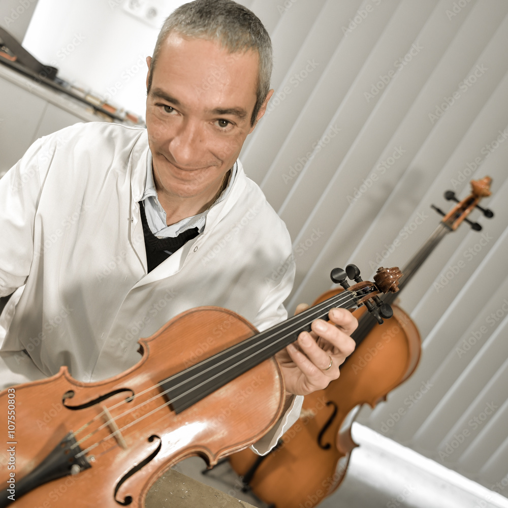 Artisan luthier working on the creation of violin. Artisan luthier working on the creation of violin.