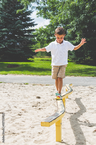 Child playing on the park play structure balance beam