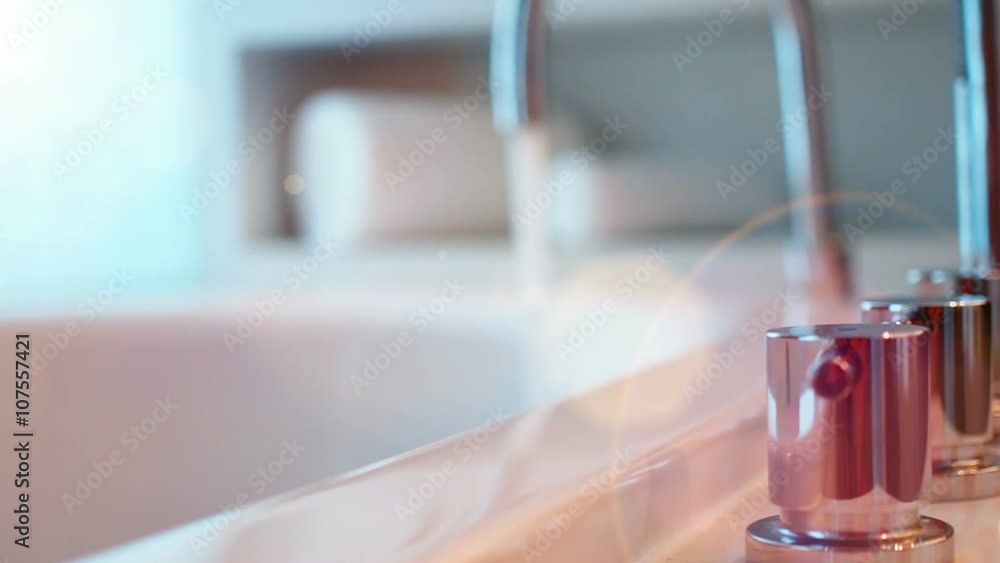 Bathtub faucet with running water, camera moving, selective focus.
Bathtub faucet with running water, camera moving, selective focus.